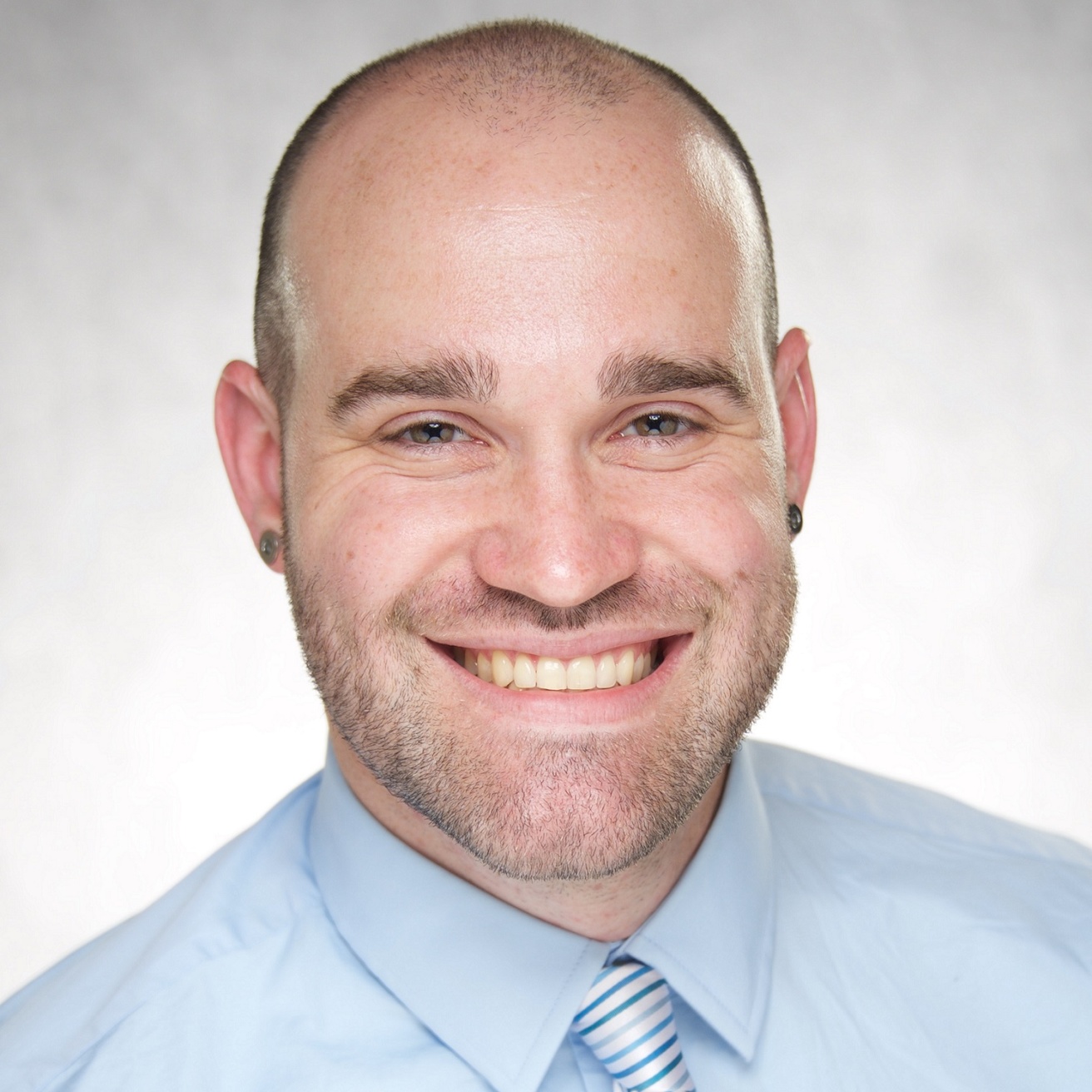 Dr. Aaron Scherer wearing a blue shirt  smiling