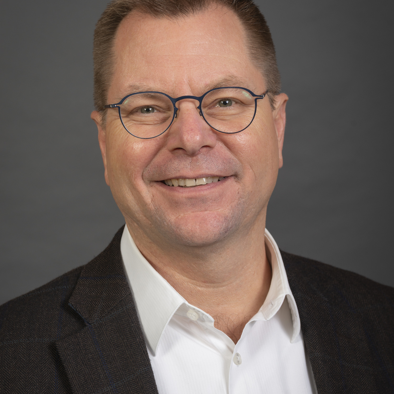 Dr. Paul Gilbert photo wearing suit jacket and glasses smiling