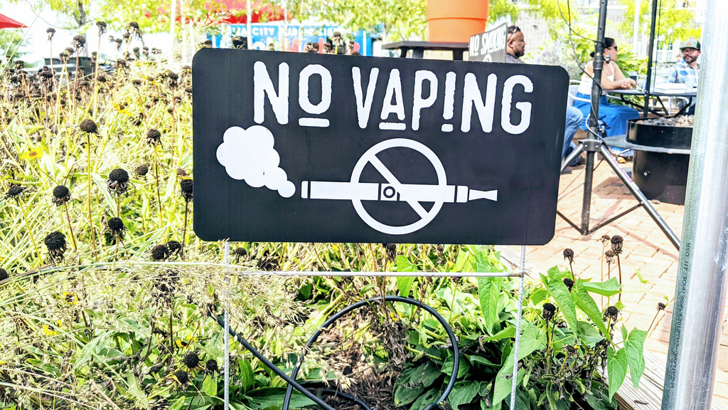 No Vaping sign posted by an outside dining area.